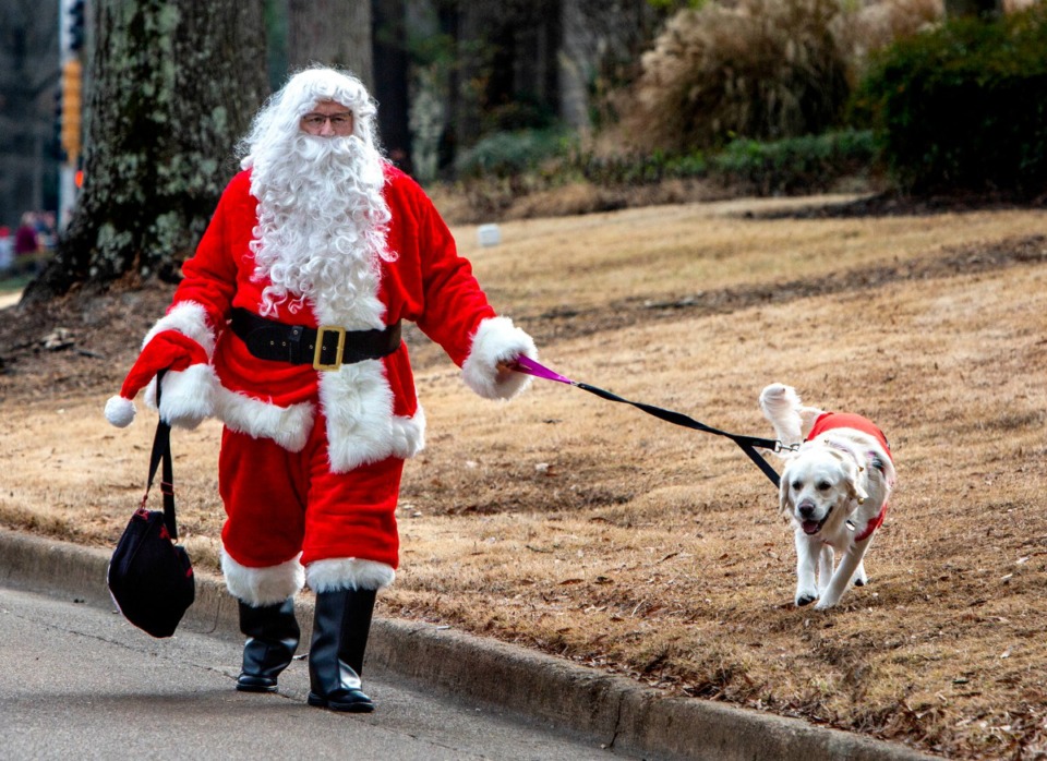 <strong>Santa Claus and his best friend stroll past floats, marching bands and others as entrants lined up along Kimbrough Road before the beginning of the Germantown Christmas parade on Dec. 14, 2019.</strong> (Mike Kerr/Special to Daily Memphian)