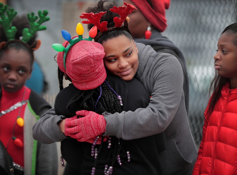 <strong>Miracle Dandridge steals a little warmth from Madison Juide while waiting for the start of the 2019 Memphis Holiday Parade on Dec. 14, 2019. The parade brought thousands to Beale Street to watch dancers, bands, floats, classic cars and Santa usher in the holiday season.</strong> (Jim Weber/Daily Memphian)