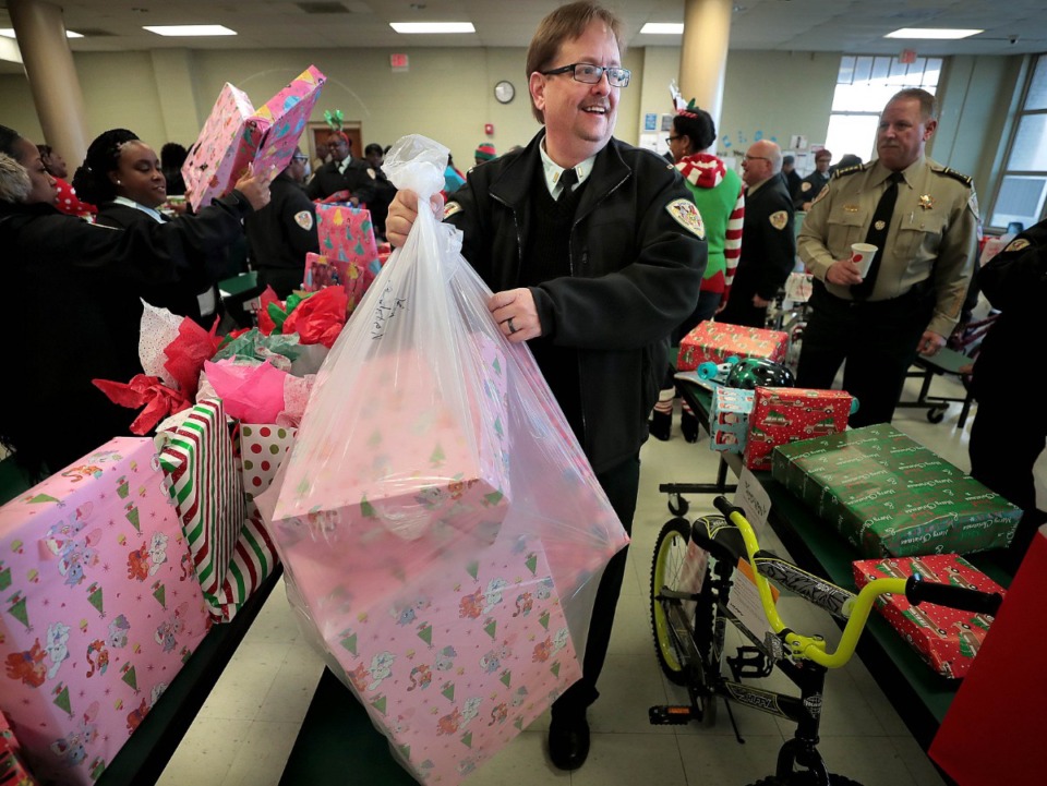 <strong>Lt. Todd Connolly (center) from the&nbsp;Shelby County Sheriff's Office helps fellow officers from the jail division unpack 55 gifts for one lucky kindergartner at Vollentine Optional Elementary School on Thursday, Dec. 19.</strong> (Jim Weber/Daily Memphian)