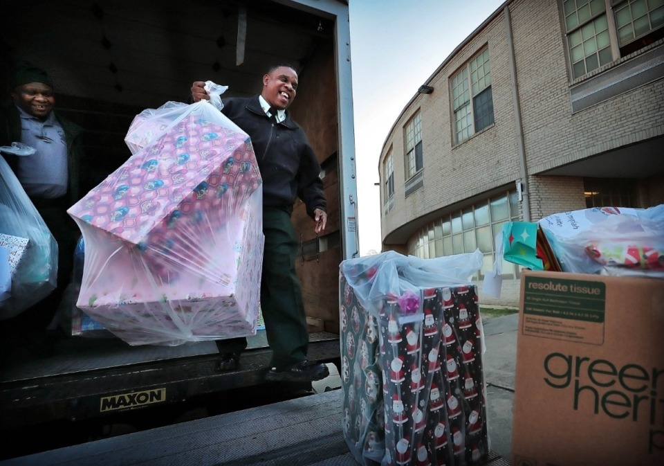 <strong>Shelby County Sheriff's officers Charles Todd (right) and H. Burnett unload a truck stacked with presents on Thursday, Dec. 19, at Vollentine Optional Elementary School.</strong> (Jim Weber/Daily Memphian)