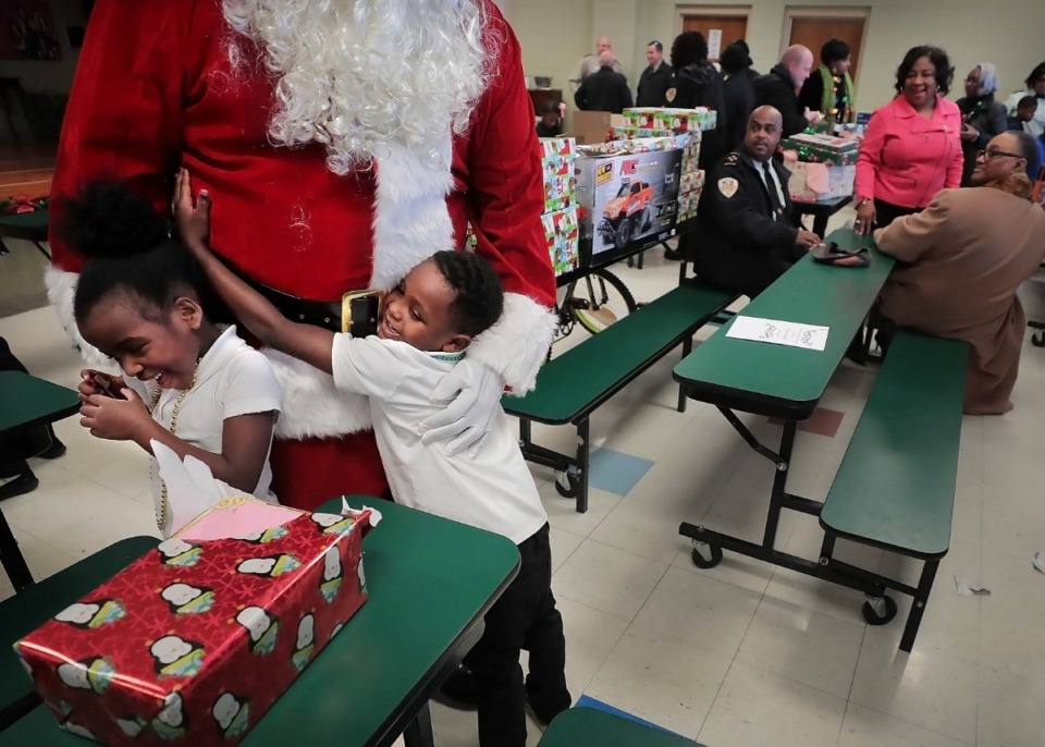 <strong>Kindergartners Zariyah Gillespie and LaDarius Peters show Santa some love as the Shelby County Sheriff's Office delivers Angel Tree gifts to students at Vollentine Optional Elementary School on Thursday, Dec. 19.</strong> (Jim Weber/Daily Memphian)