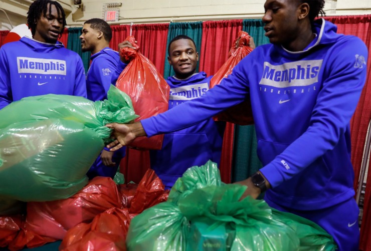 <strong>Alex Lomax (middle) along with his University of Memphis men's basketball teammates handed out gifts during a toy giveaway on Dec. 20, 2019, at the Davis Community Center.</strong> (Mark Weber/Daily Memphian)