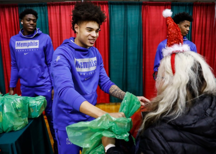 <strong>Lester Quinones (middle) along with his Memphis men's basketball teammates handed out gifts during a toy giveaway on Dec. 20, 2019, at the Davis Community Center.</strong> (Mark Weber/Daily Memphian)