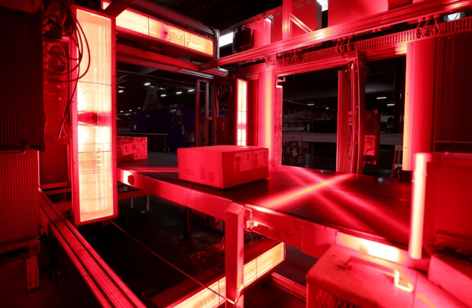 <strong>A lot of the sorting at the FedEx Ground hub in Olive Branch, Mississippi is automatic and done by laser, such as this bright crimson checkpoint several packages sweep through on Dec. 2, 2019.</strong> (Patrick Lantrip/Daily Memphian file)