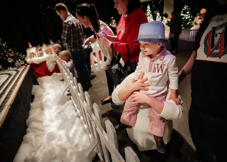 <strong>Vivian Wright gives her son Roman Wright, 2, a boost to better see the electric train display during a visit to the Enchanted Forest at the Pink Palace on Dec. 24, 2019.&nbsp;</strong><strong>The Enchanted Forest has been a holiday attraction in Memphis for more than 50 years, beginning its life in Goldsmith's Department Store with some of the same animatronic characters which still reside in the exhibit.</strong> (Jim Weber/Daily Memphian)