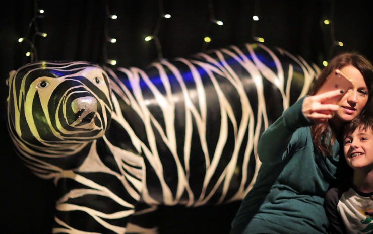 <strong>Andrea Cox and her son Anderson Cox, 7, get a selfie with the fantastical zebra-striped polar bear during a visit to the Enchanted Forest exhibit at the Pink Palace on Dec. 24, 2019. The Enchanted Forest has been a holiday attraction in Memphis for more than 50 years, beginning its life in Goldsmith's Department Store with some of the same animatronic characters which still reside in the exhibit. </strong>(Jim Weber/Daily Memphian)