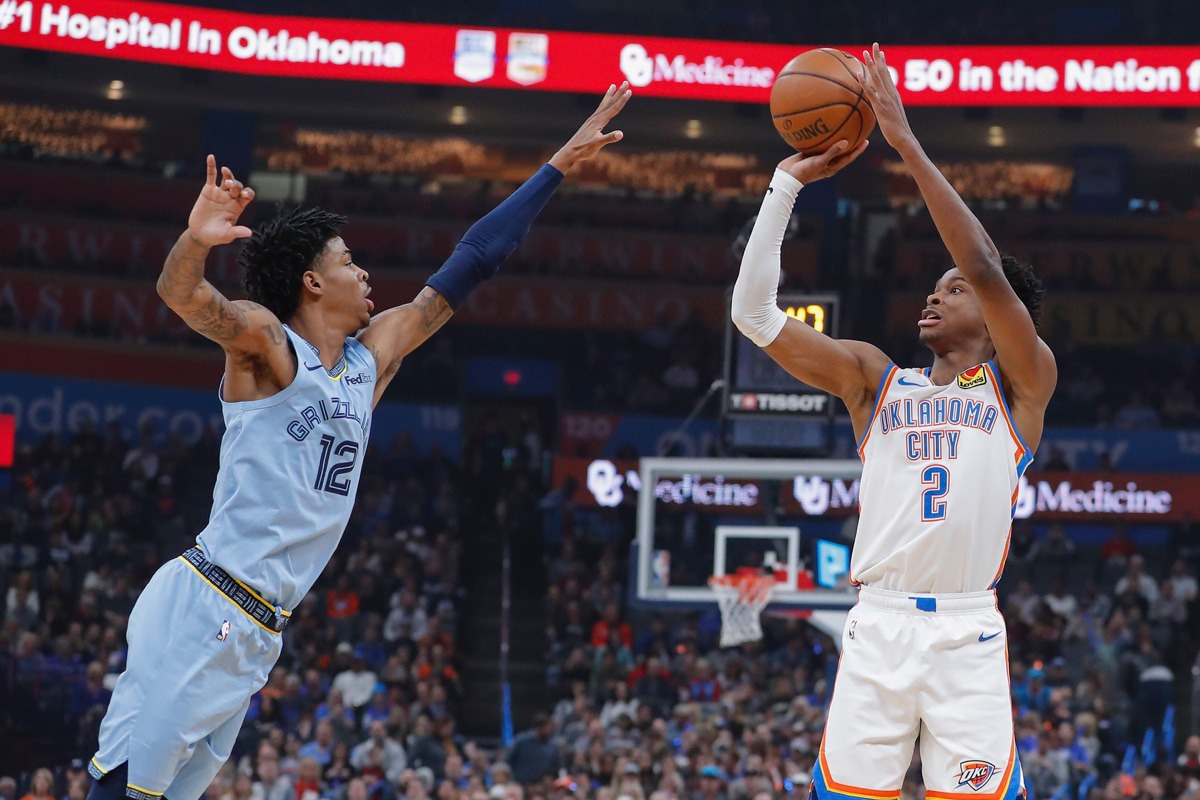 <strong>Grizzlies guard Ja Morant (12) tries to block Oklahoma City Thunder guard Shai Gilgeous-Alexander (2) Dec. 26 in Oklahoma City.</strong> (Alonzo Adams/AP)