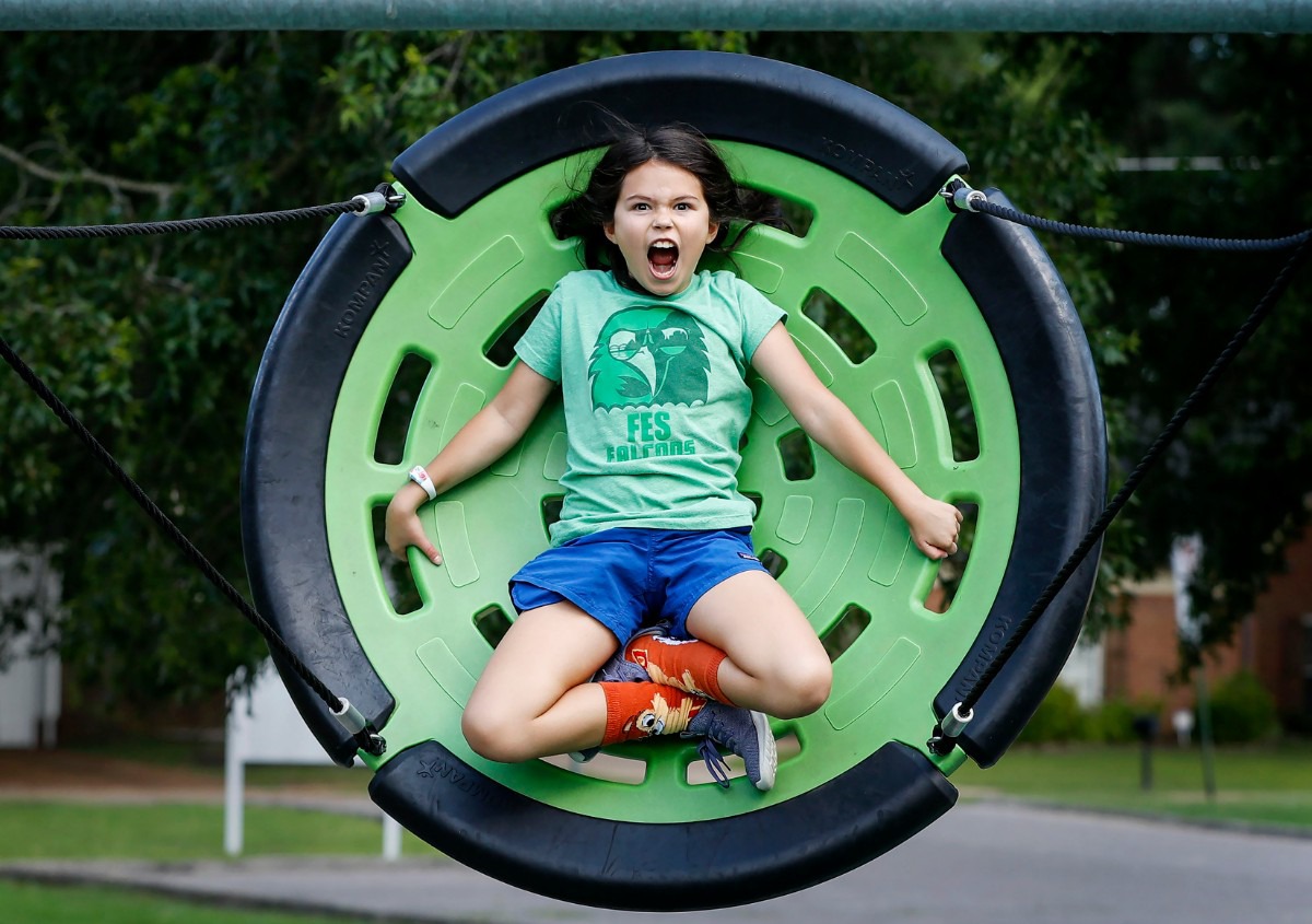 <strong>Farmington Elementary School student Lyla Brower, 11, screams while swinging high at Farmington Park on Aug. 1, 2019. Germantown is looking at establishing rules that would limit time the public can play at its public parks, designating them for school use during school hours at parks adjacent to schools.</strong> (Mark Weber/Daily Memphian)