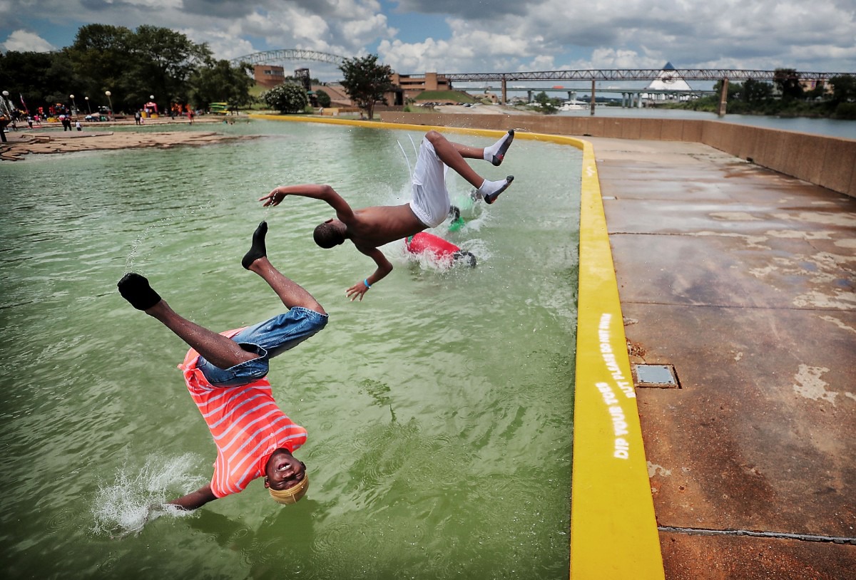 <strong>Unable to resist the cool water on a hot day, Terrance Gaither (left) and Tysean Gaither take a plunge in Mud Island's Gulf of Mexico during dueling events on July 13, 2019, at Mud Island River Park. Families turned out for the Big Birthday Bash to celebrate summer birthdays and for the Superhero Training Day, where kids learned about superheroes as a way of becoming more responsible citizens.</strong> (Jim Weber/Daily Memphian)