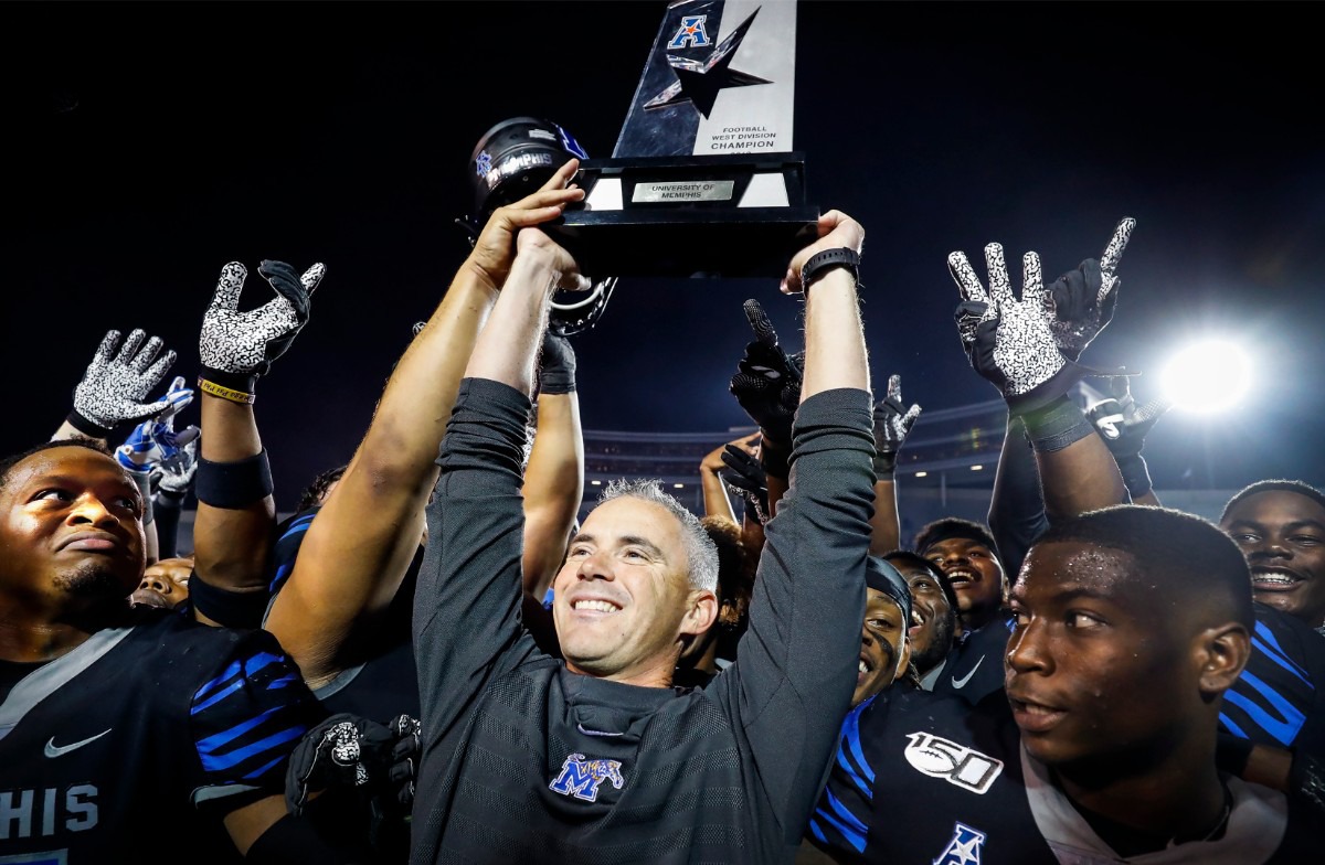 <strong>University of Memphis head coach Mike Norvell (middle) hoists the AAC Western Division Champion Trophy after defeating Cincinnati on Nov. 29, 2019, at the Liberty Bowl Memorial Stadium.</strong> (Mark Weber/Daily Memphian)