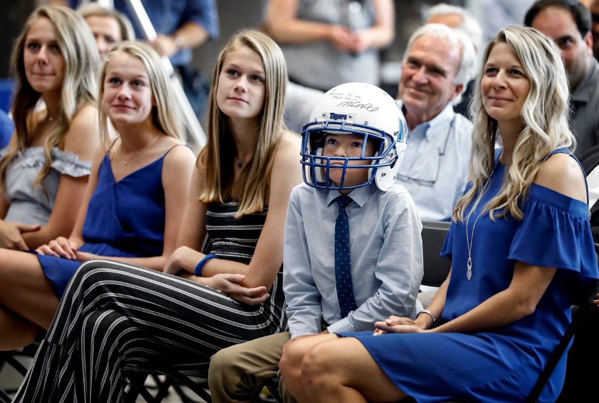<strong>While wearing a University of Memphis football helmet, Dru Veatch looks on as his father Laird Veatch is named the school's new athletic director during a press conference at the Laurie-Walton Family Basketball Center on Aug. 13, 2019.</strong> (Mark Weber/Daily Memphian)