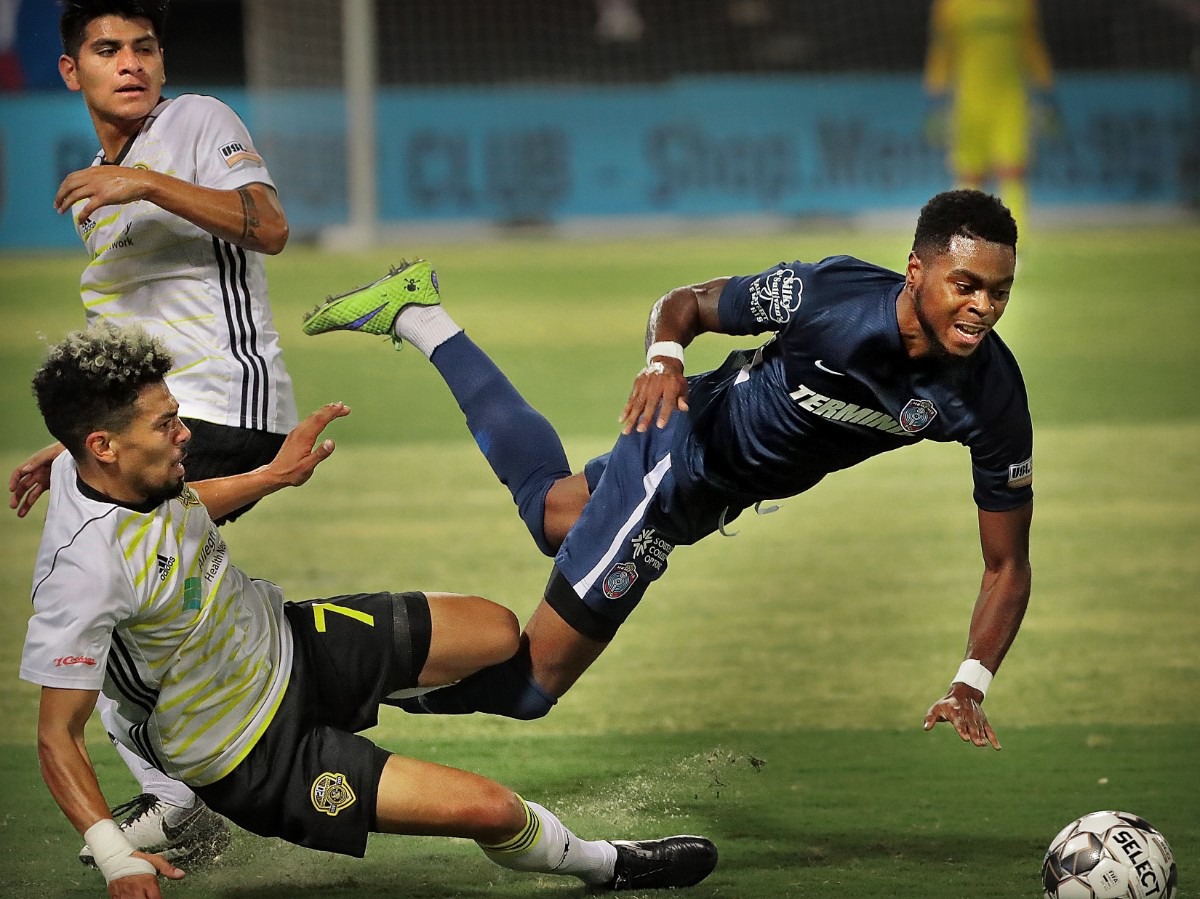 <strong>Memphis midfielder Marcus Epps (right) is tripped up by the Riverhounds' Ryan James (7) during 901FC's 0-1 loss to Pittsburgh at AutoZone Park on Sept. 24, 2019.</strong> (Jim Weber/Daily Memphian)