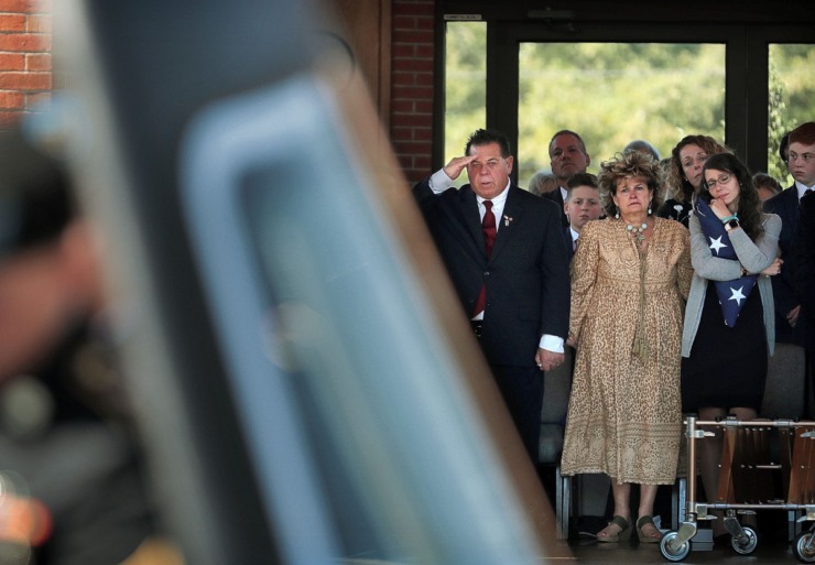 <strong>Erin Joseph (right), wife of Major Trevor Joseph, clutches the flag presented to her as she stands with the soldier's parents, Nancy Joseph and Pete Joseph (left), watching the casket being taken away during an Oct. 8, 2019, memorial service at the West Tennessee State Veterans Cemetery for the Houston High graduate and Medevac pilot who was killed in a helicopter crash in September in Louisiana.</strong> (Jim Weber/Daily Memphian)