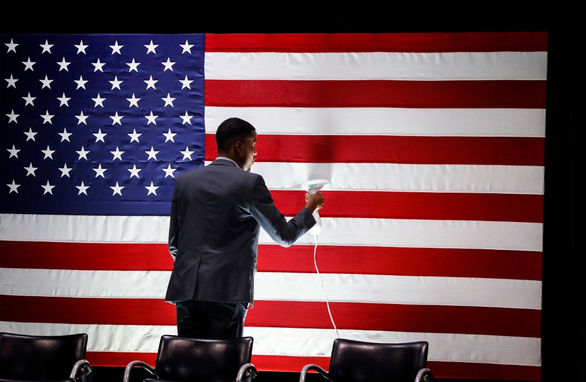 <strong>Kelvin Johnson steams a U.S. flag before Democratic presidential contender Michael Bloomberg's campaign stop in Memphis at the Benjamin L. Hooks Central Library on Dec. 18, 2019.</strong> (Mark Weber/Daily Memphian)