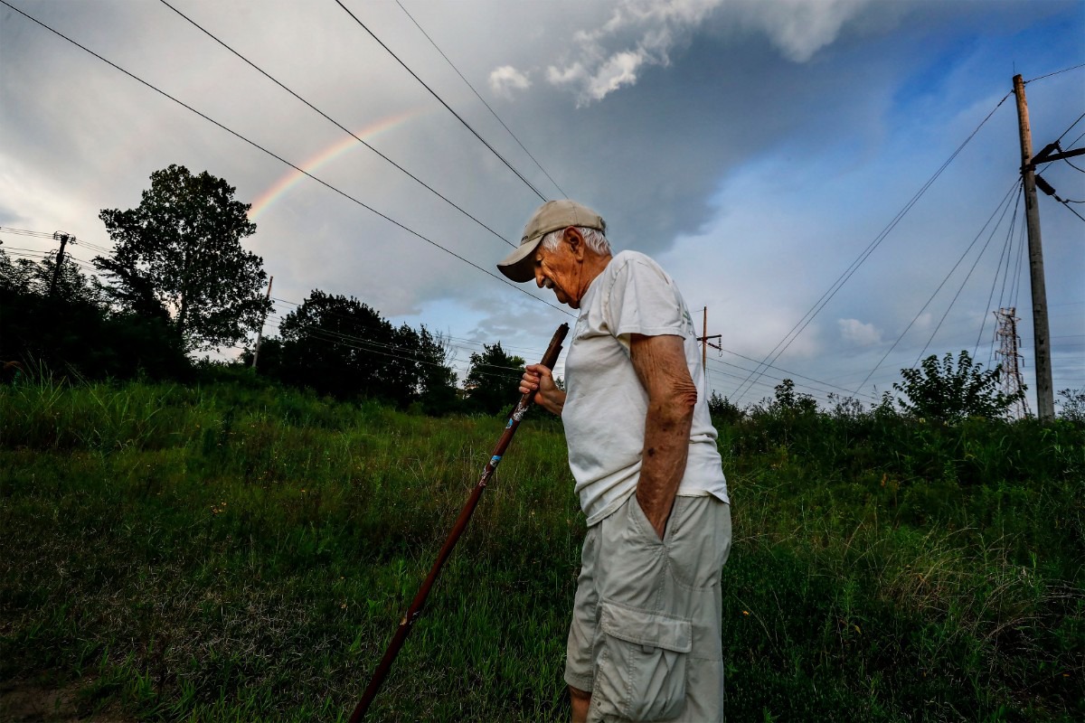 <strong>As a rainbow arcs across the evening sky, Nonconnah Creek Conservancy member Gene McKenzie hikes through Nash-Buckingham Park near Getwell Road on July 20, 2019.</strong> (Mark Weber/Daily Memphian)