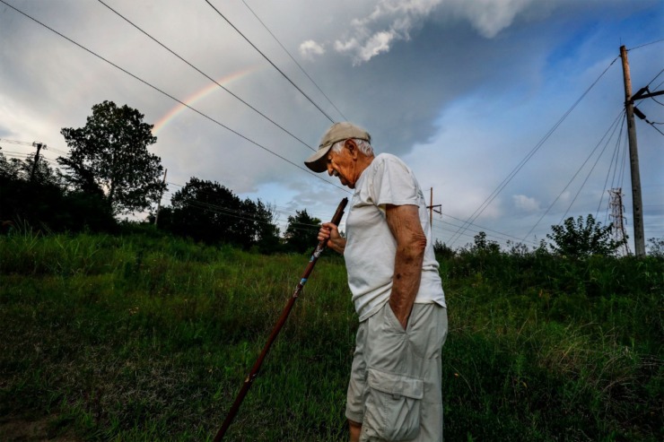 <strong>As a rainbow arcs across the evening sky, Nonconnah Creek Conservancy member Gene McKenzie hikes through Nash-Buckingham Park near Getwell Road on July 20, 2019.</strong> (Mark Weber/Daily Memphian)