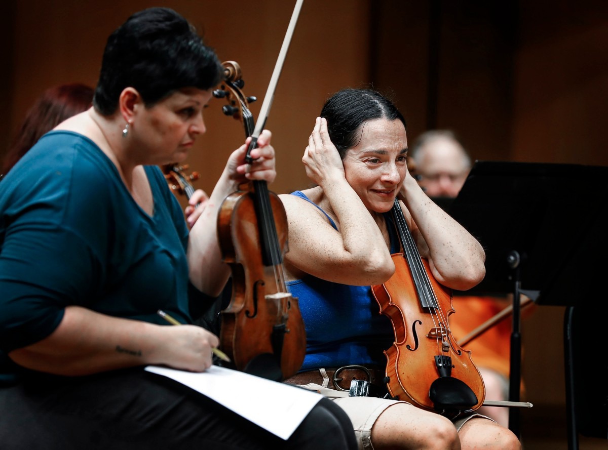 <strong>Memphis Symphony Orchestra violinist Marisa Polesky covers her ears as the brass section rehearses at the Cannon Center on Sept. 17, 2019, ahead of the start of the new season on Sept. 28.</strong> (Mark Weber/Daily Memphian)