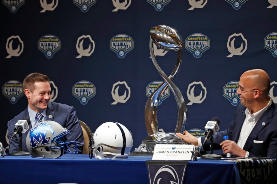 <strong>Memphis head coach Ryan Silverfield (left) laughs as Penn State head coach James Franklin (right) slowly pulls the Cotton Bowl trophy towards himself during a press conference for the Cotton Bowl NCAA college football game, on Dec. 27, 2019, in Arlington, Texas.</strong> (James D. Smith/AP)