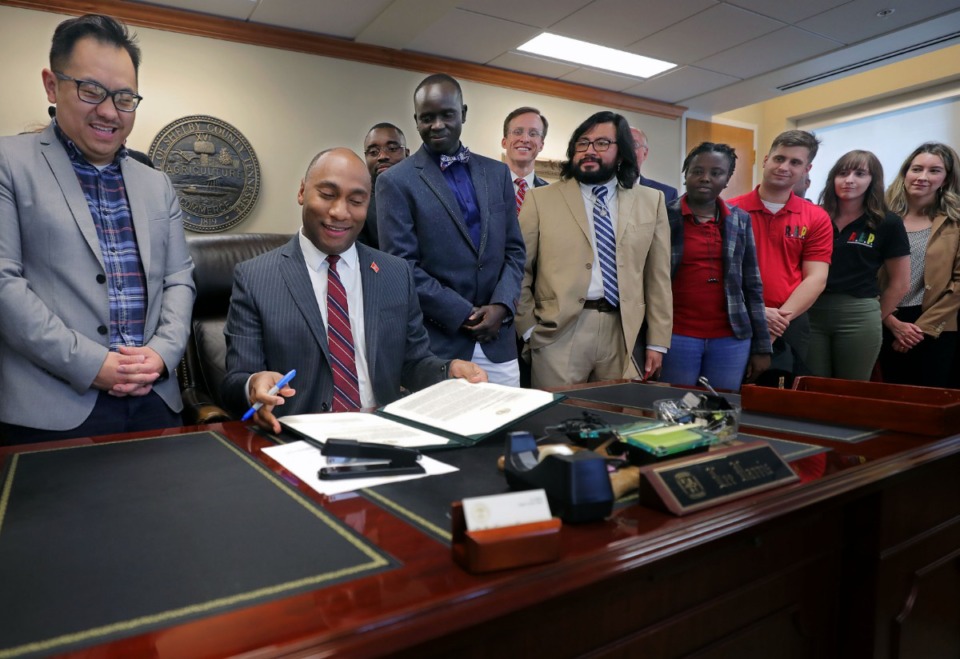 <strong>Surrounded by members of the local refugee community on Friday, Jan. 3, Shelby County Mayor Lee Harris signs a ceremonial copy of a letter&nbsp;<span>that was sent to the U.S. State Department confirming that the county would continue to accept refugees.</span></strong>&nbsp;(Patrick Lantrip/Daily Memphian)
