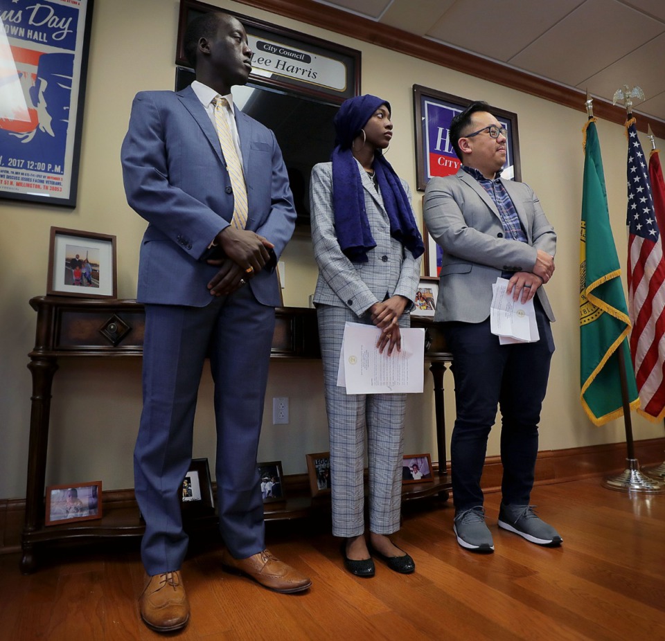 <strong>Isaac James (from left), Faten Hawasha and Cute Lee stand by as Shelby County Mayor Lee Harris prepares to sign a document on Friday, Jan. 3, affirming the county's consent to continue resettling refugees.</strong> (Patrick Lantrip/Daily Memphian)