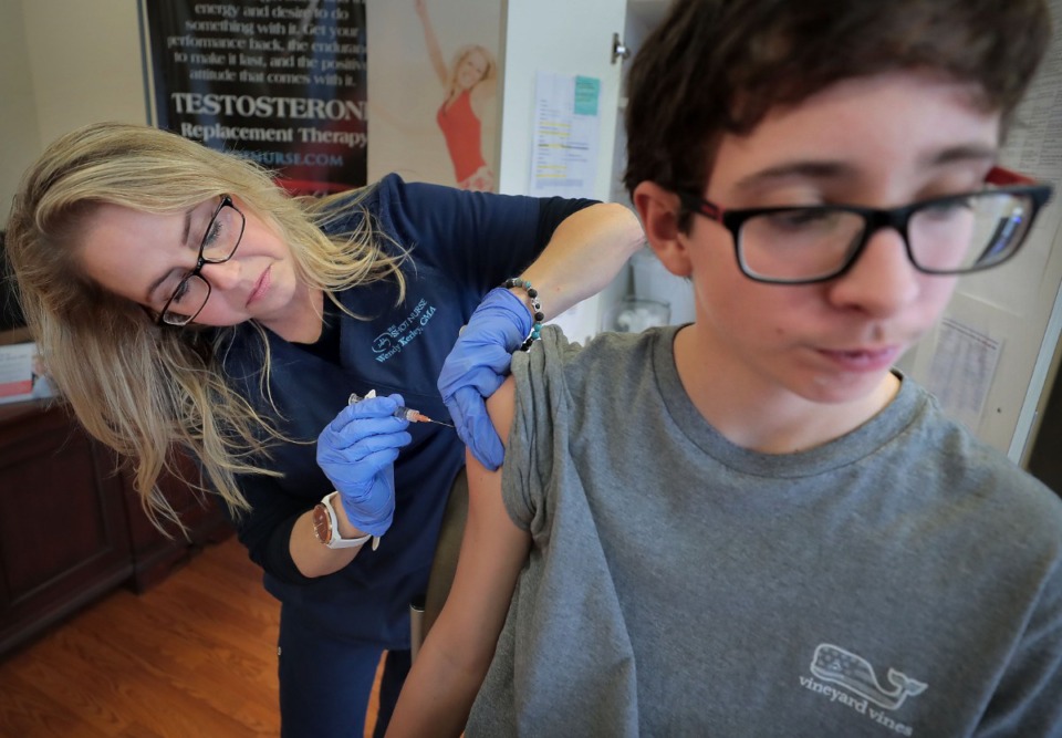 <strong>CMA Wendy Kerley gives Ethan Getman, 15, a shot of the flu vaccine while inoculating the Getman family on Jan. 3, 2019, at the Cordova Shot Nurse clinic on Germantown Road. </strong>(Jim Weber/Daily Memphian)