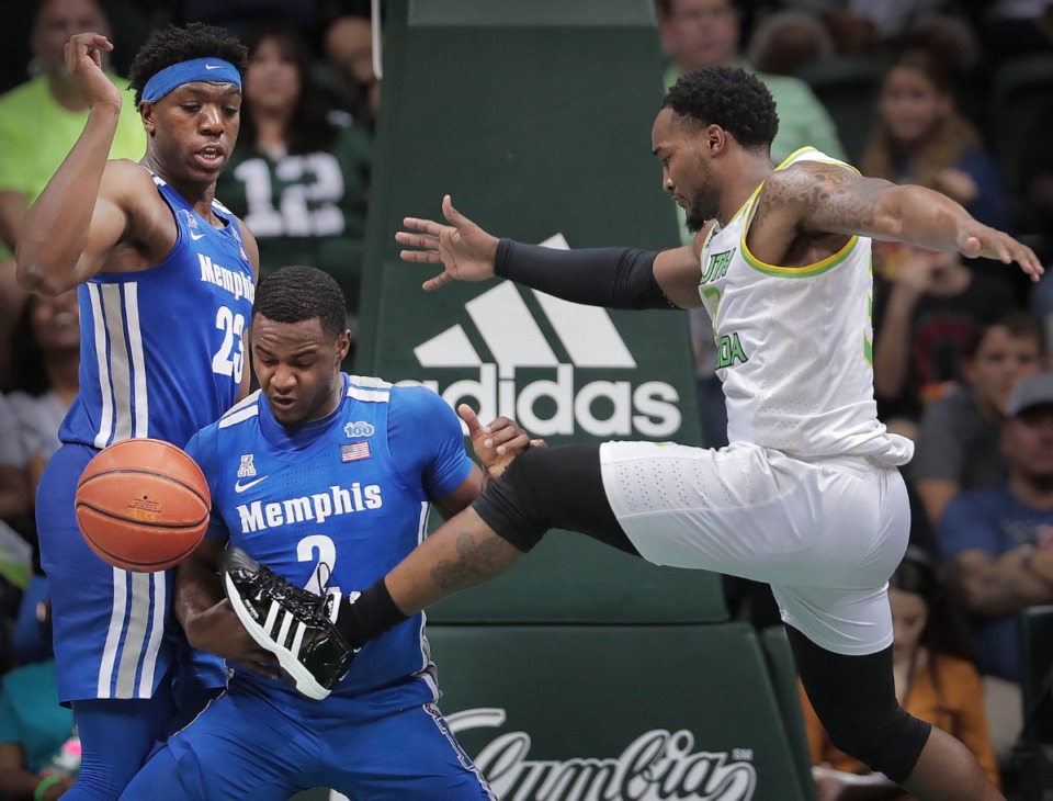 <strong>University of Memphis guard Alex Lomax (2) and Malcolm Dandridge (left) scramble for a rebound under pressure by the Bulls' Laquincy Rideau (right) during the Tigers' game on Jan. 12, 2020, against USF at the Yuengling Center.</strong> (Jim Weber/Daily Memphian)