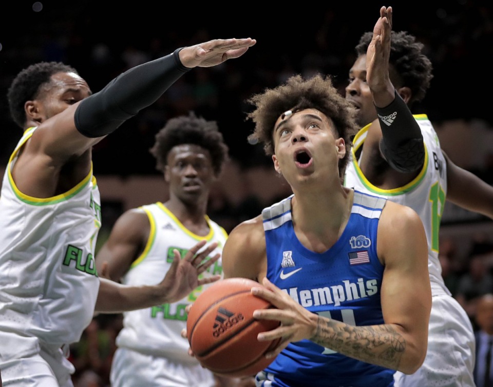 <strong>University of Memphis guard Lester Quinones shoots under pressure by the Bulls' Laquincy Rideau (left) and Justin Brown (right) during the Tigers' game on Jan. 12, 2020, against USF at the Yuengling Center.</strong> (Jim Weber/Daily Memphian)