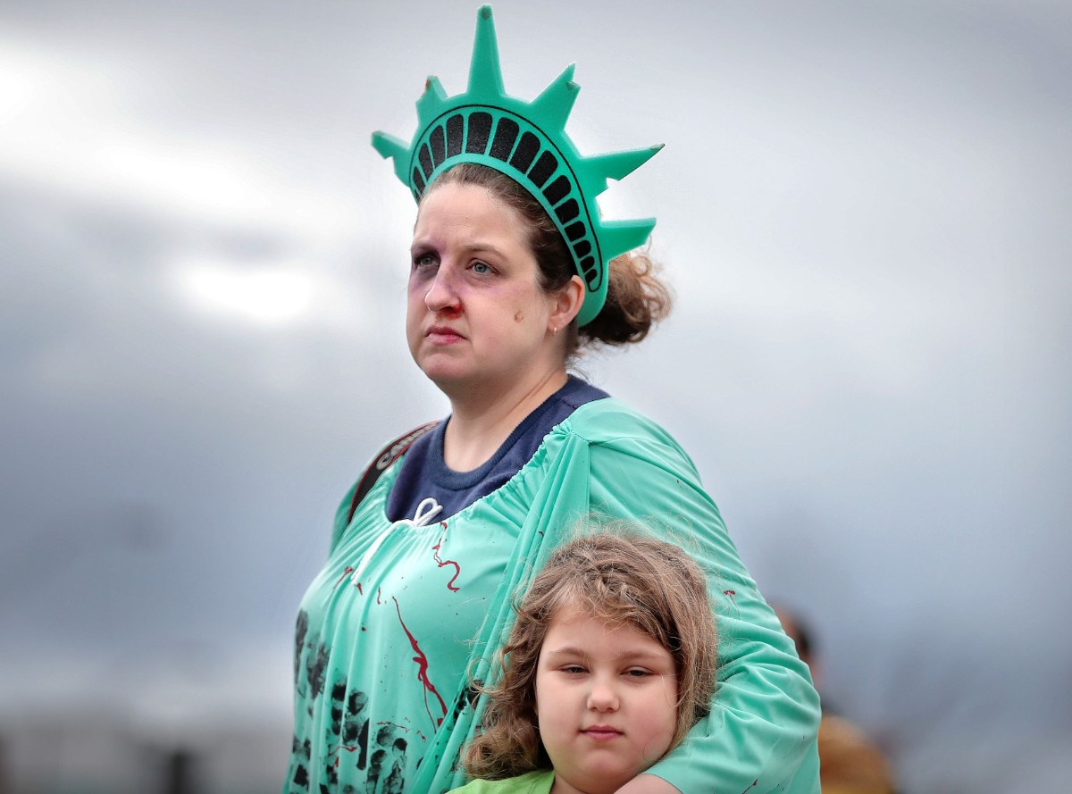 <strong>Ariel Britton-Hodge and her daughter Emeline, 7, listen to speakers at the National Civil Rights Museum after the Memphis Women's March Downtown on Jan. 18, 2020, as over 250 women's rights advocates gathered in the shadow of a looming election year to build awareness for equality, reproductive rights and discrimination issues.</strong> (Jim Weber/Daily Memphian)