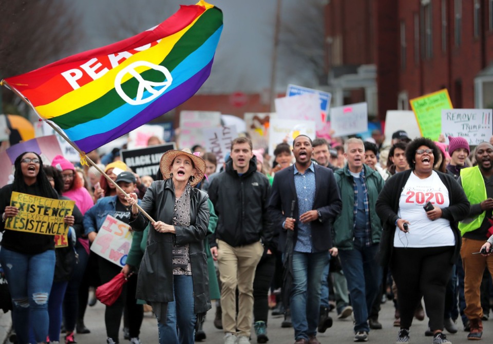 <strong>Peace flag in hand, Patty Crawford (left) leads the Memphis Women's March Downtown on Jan. 18, 2020, as over 250 women's rights advocates gathered in the shadow of a looming election year to build awareness for equality, reproductive rights and discrimination issues.</strong> (Jim Weber/Daily Memphian)