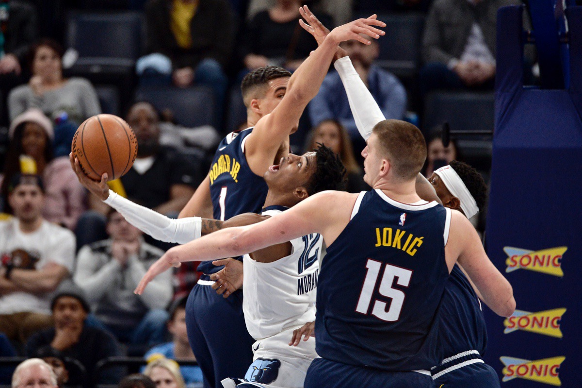 <strong>Memphis Grizzlies guard Ja Morant (12) shoots between Denver Nuggets center Nikola Jokic (15) and forward Michael Porter Jr. (1) Jan. 28, 2020, at FedExForum.</strong> (Brandon Dill/AP)