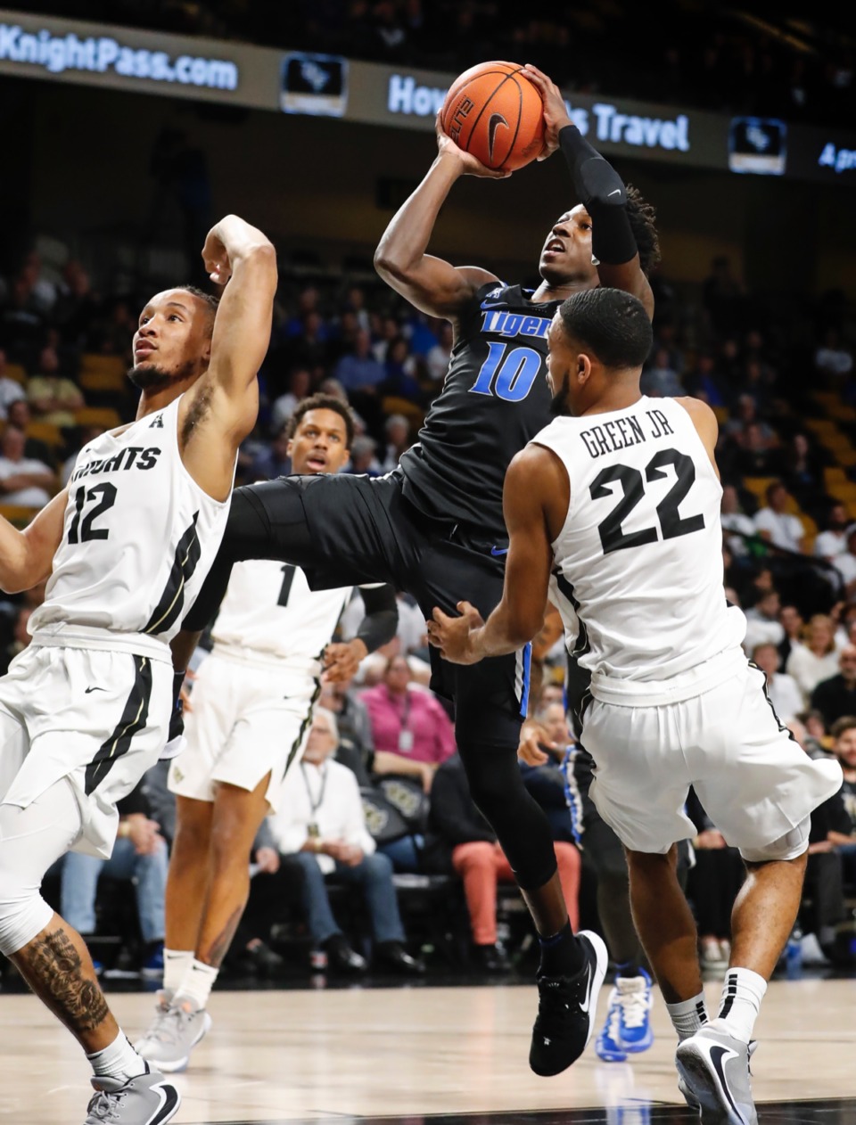 <strong>Memphis guard Damion Baugh (middle) is called for a charging foul while driving the lane against UCF defenders Dazon Ingram (left) and Darin Green Jr. (right) Jan. 29, 2020, in Orlando.</strong> (Mark Weber/Daily Memphian)