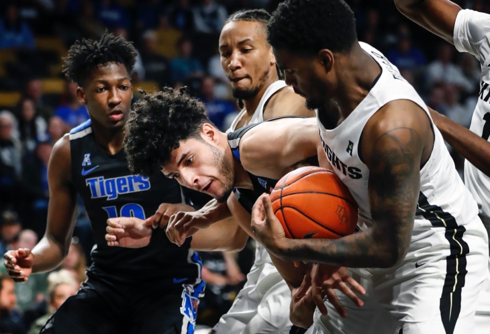 <strong>Memphis forward Isaiah Maurice (middle) has a rebound stripped away by UCF defender Dre Fuller Jr. (right) during action on Wednesday, Jan. 29, 2020, in Orlando.</strong> (Mark Weber/Daily Memphian)