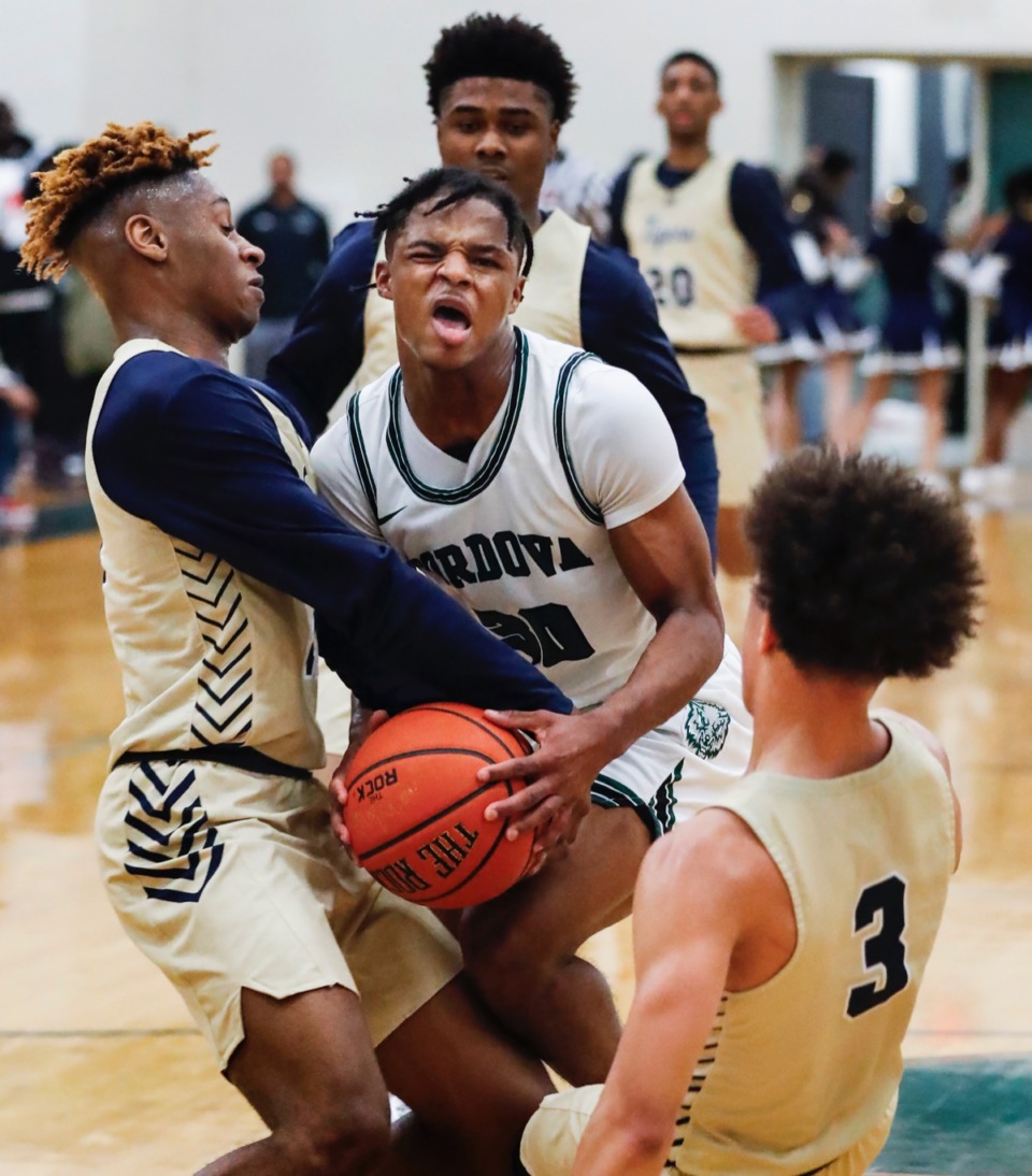 <strong>Cordova guard Dwight Deberry (middle) loses control the ball while running into Arlington defenders Madison Peaster (left) and Philip Dotson (right) Jan. 31, 2020.</strong> (Mark Weber/Daily Memphian)