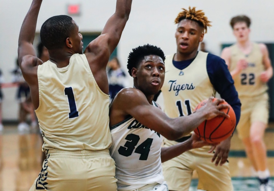 <strong>Cordova forward K&rsquo;Juan Banks (middle) drives for a layup against Arlington defenders Christopher Mcknight (left) and Madison Peaster (right) Jan. 31, 2020.</strong> (Mark Weber/Daily Memphian)