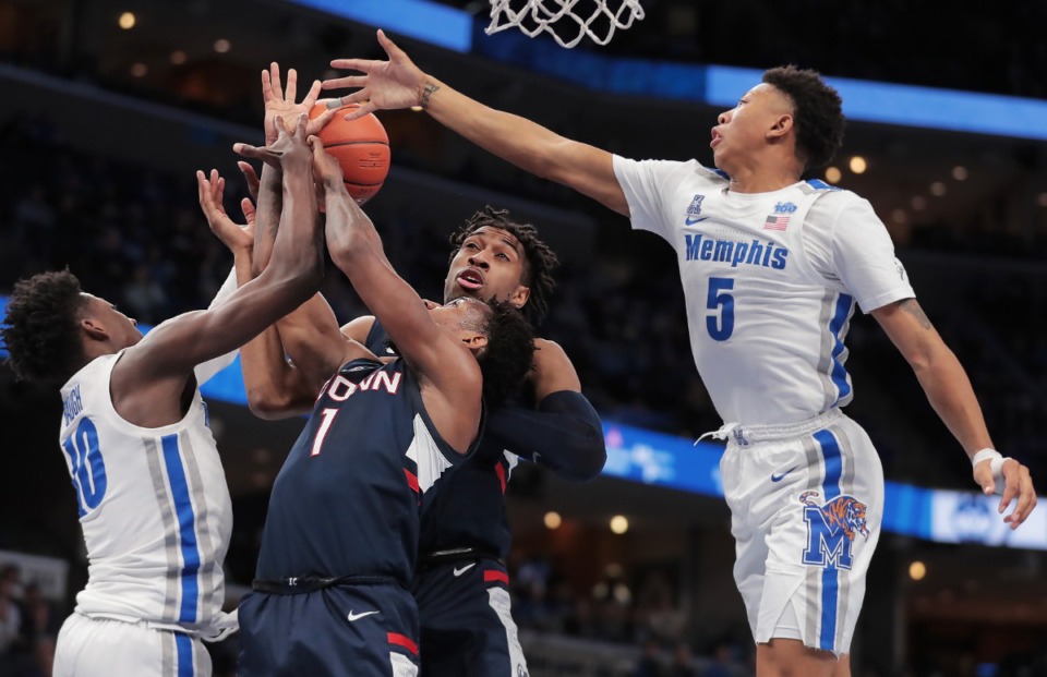<p class="p1"><span class="s1"><strong>University of Memphis guards Damion Baugh (left) and Boogie Ellis (5) battle for a rebound with the Huskies' Christian Vital (1) and Isaiah Whaley during the Tigers' game on Feb. 1, 2020, against Connecticut at FedExForum in Memphis. </strong>(Jim Weber/Daily Memphian)</span>