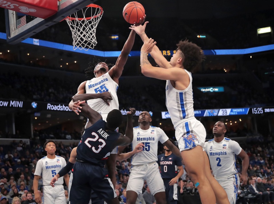 <strong>University of Memphis forward Precious Achiuwa (55) and guard Lester Quinones pull down a rebound under pressure by the Huskies' Akok Akok (23) during the Tigers' game on Feb. 1, 2020, against Connecticut at FedExForum in Memphis.</strong> (Jim Weber/Daily Memphian)