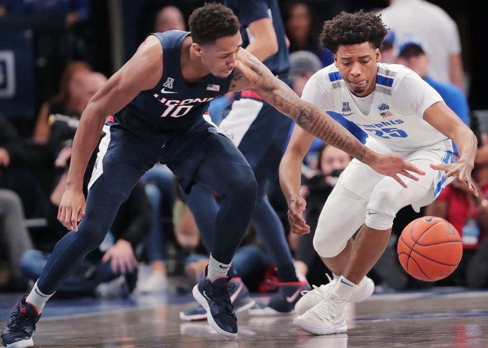 <strong>University of Memphis guard Jayden Hardaway (25) scrambles for a loose ball under pressure by the Huskies' Brendan Adams (10) during the Tigers' game on Feb. 1, 2020, against Connecticut at FedExForum in Memphis.</strong> (Jim Weber/Daily Memphian)