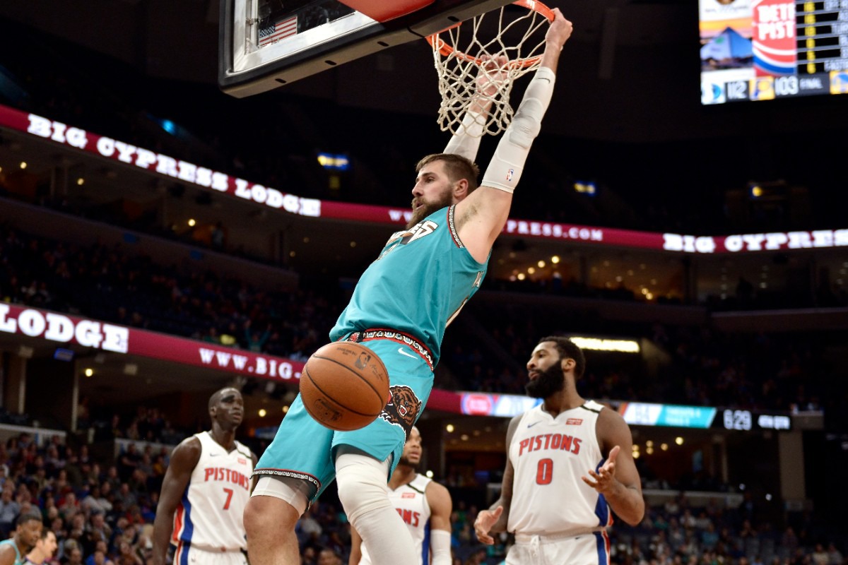 <strong>Memphis Grizzlies center Jonas Valanciunas hangs from the rim after a dunk Feb. 3, 2020, in the game against Detroit at FedExForum.</strong> (Brandon Dill/AP)