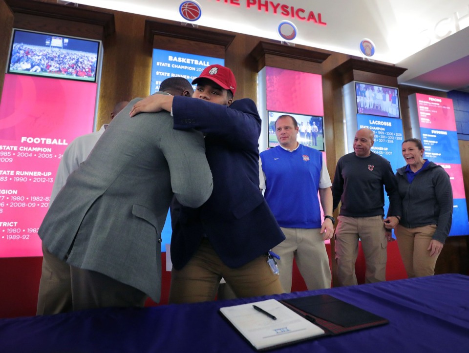 <strong>Memphis University School prospect Marcus Henderson (center) is embraced by his high school coaching staff after signing a letter of intent on Wednesday, Feb. 5, to play football for the University of Arkansas.</strong> (Patrick Lantrip/Daily Memphian)