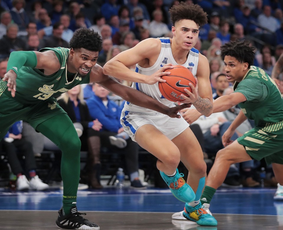 <strong>University of Memphis guard Lester Quinones finds an opening between the Bulls' Justin Brown (13) and Xavier Castaneda (right) during the Tigers' game on Feb. 8, 2020, against USF at FedExForum in Memphis.</strong> (Jim Weber/Daily Memphian)