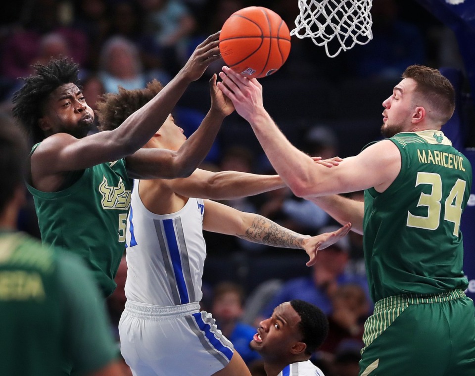 <strong>Bulls guard Rashun Williams (5) and forward Antun Maricevic pull down a rebound under pressure by University of Memphis guard Lester Quinones during the Tigers' game on Feb. 8, 2020, against USF at FedExForum in Memphis.</strong> (Jim Weber/Daily Memphian)