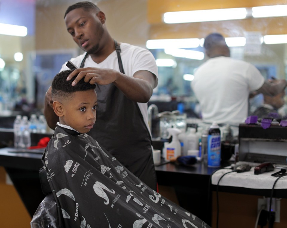 <strong>Success Barber College student Mikeal Hunt gives his young client a haircut Feb. 1, 2020. A 2016 ICED loan enabled owner Morris Wilder, a Whitehaven native and resident, to establish the school near the intersection of Shelby Drive and Millbranch Road.</strong> (Patrick Lantrip/Daily Memphian)