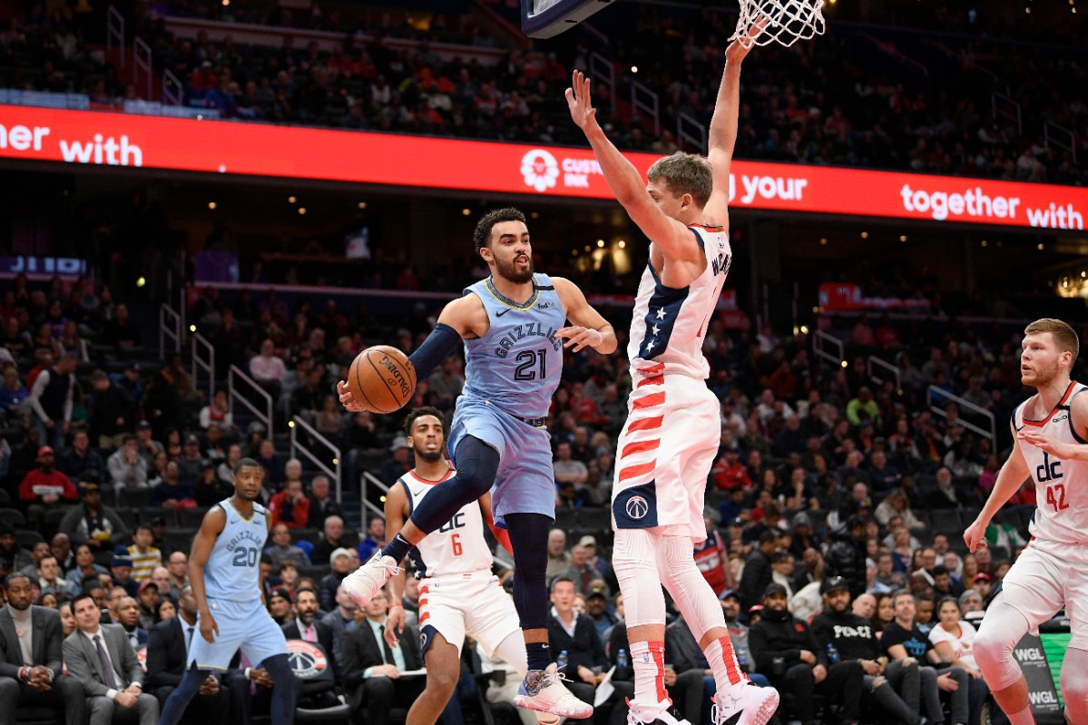 <strong>Memphis Grizzlies guard Tyus Jones (21) looks to pass next to Washington Wizards forward Moritz Wagner (center right) during the first half of an NBA game on Feb. 9, 2020, in Washington.</strong> (AP Photo/Nick Wass)