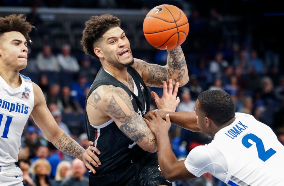 <strong>Memphis defender Alex Lomax (right) fouls Cincinnati guard Jarron Cumberland (middle) as teammates Lester Quinones (left) helps on the play during action on Jan. 16, 2020, at FedExFourm.</strong> (Mark Weber/Daily Memphian file)