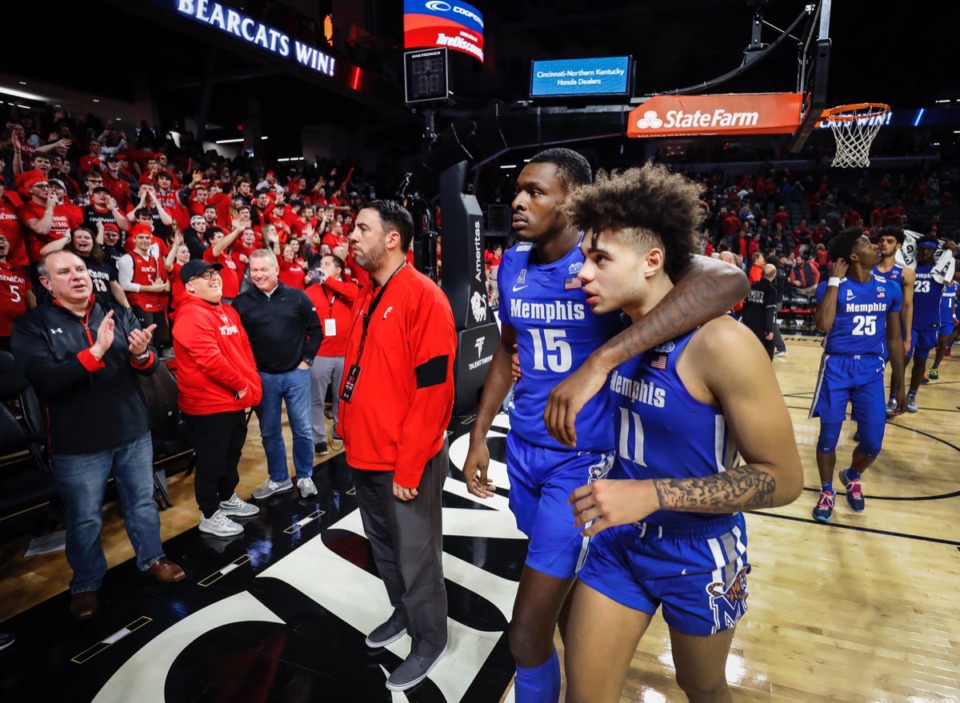 <strong>Memphis teammates Lance Thomas (middle) and Lester Quinones (right) walk off the court as the Cincinnati fans cheer after the Tigers lost 92-86 in overtime Thursday, Feb. 13, 2020.</strong> (Mark Weber/Daily Memphian)