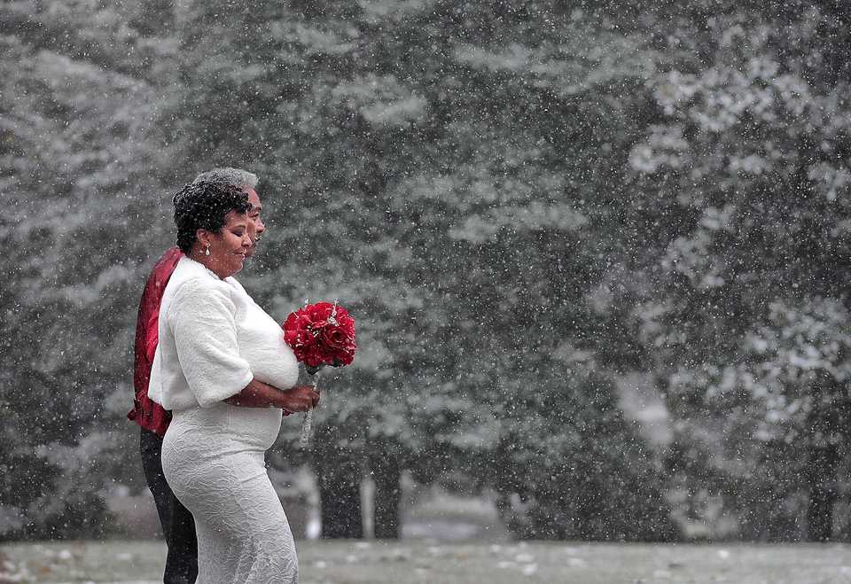 <strong>Mark Martin walks his daughter Tamika Kerr down a white path at Overton Park in Midtown Memphis as she ties the knot in a surprise snowy wedding on Nov. 14, 2018.</strong> (Jim Weber/Daily Memphian)