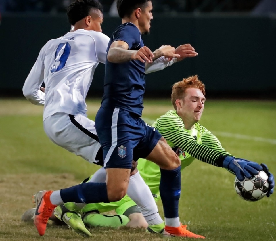<strong>Tigers goalkeeper Parker Lackland (1) dives for a save as Memphis 901 FC forward Pierre Da Silva (11) closes in for a shot during 901 FC's preseason exhibition game against the University of Memphis at AutoZone Park on Feb. 29, 2020.</strong> (Jim Weber/Daily Memphian)