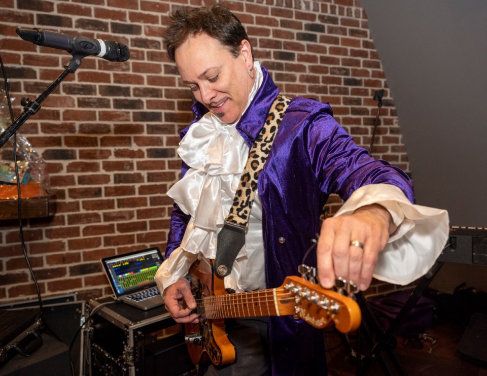 <strong>Kevin Paige tunes up before he and his wife Bethany perform at the Collierville Cares 80's Prom fundraiser for Friends of Collierviille Animal Services, Saturday, Feb. 29, 2020 in Collierville.</strong> (Greg Campbell/Special to The Daily Memphian)