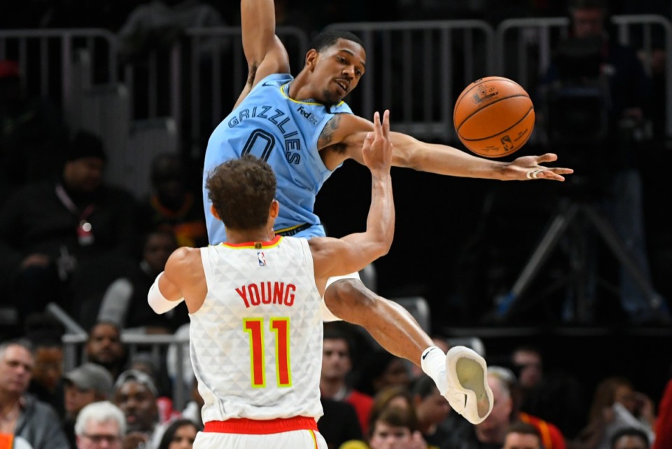 <strong>Memphis Grizzlies guard De'Anthony Melton, top, reaches for a pass as Atlanta Hawks guard Trae Young (11) defends March 2, 2020, in Atlanta.</strong>&nbsp;(John Amis/AP)