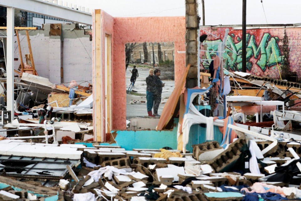 <strong>People are reflected in a mirror of a building destroyed by storms Tuesday, March 3, 2020, in Nashville, Tennessee. Tornadoes ripped across Tennessee early Tuesday, shredding buildings and killing multiple people.</strong> (AP Photo/Mark Humphrey)